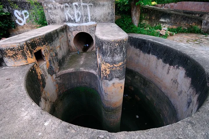 Una antigua estructura de hormigón para la gestión del agua con piletas circulares y una tubería.